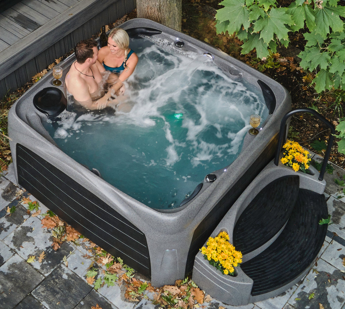 A couple enjoying a Dream Maker Crossover hot tub outdoors